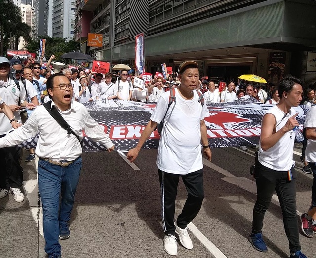 直到隊伍快要離開灣仔，進入金鐘的時候，我才發現一直站在隊伍最前面也最中間的，不是別人，而是長年以來最堅持反共，也引起過無數爭議的港台傳媒大亨黎智英。(圖片來源：趙君朔/攝)