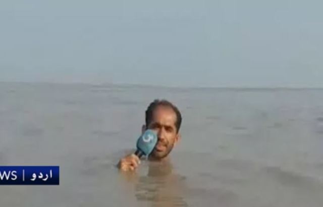 記者整個人浸到淹水中。(翻攝巴基斯坦《G TV》)