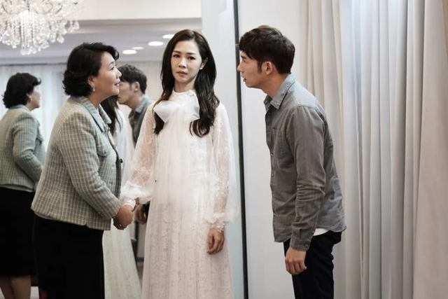 (左)江媽(王娟 飾)，插手為陳嘉玲(謝盈萱 飾)挑選婚紗
