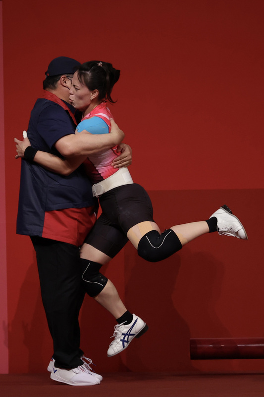 郭婞淳東奧舉重摘金，與教練相擁露出微妙表情。（中央社）