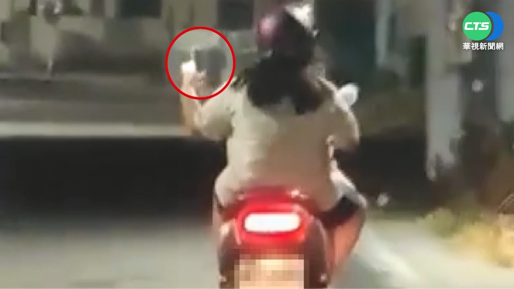 孩站腳踏墊 女單手騎機車滑手機嚇壞旁人