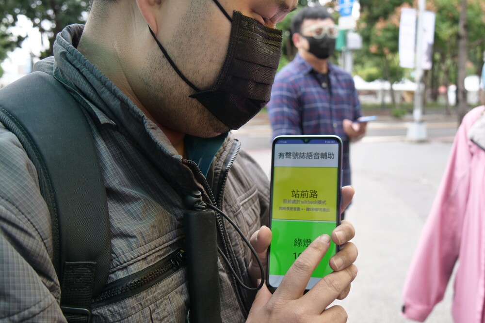 視障者使用智慧有聲號誌，掌握行人號誌綠燈剩餘秒數。圖／新北交通局提供